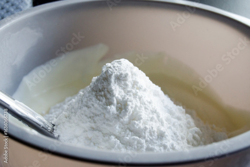 Fotografija Powdered or icing sugar in plastic bowl.