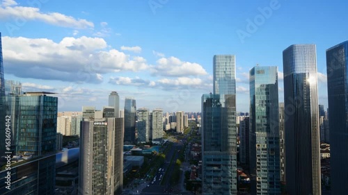Aerial Cityscape Hyper-Realistic Tilt-Shifted View of Modern Glass and Steel Skyscrapers — 4K HD Video Footage Download, Vibrant Blue Sky, Futuristic Urban Skyline