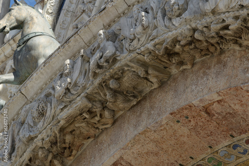 Fotografi Detail of sculpted archivolt with allegorical figures and floral motifs on the facade of St