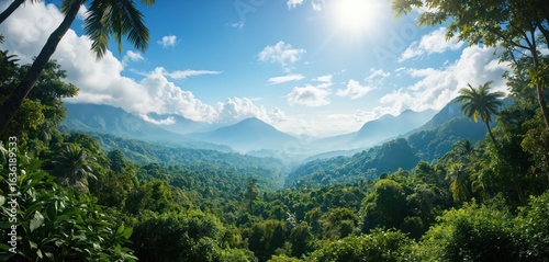 Fototapeta Naklejka Na Ścianę i Meble -  Rich jungle landscape with vibrant rainforest. Towering mountains visible through bright blue sky dotted with fluffy clouds, creating serene, breathtaking panoramic view. Tropical nature, vacation,