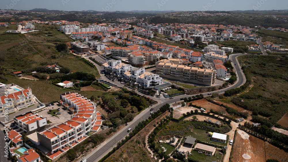 Aerial View of Coastal Town with Red-Tiled Roofs and Surrounding Countryside Aerial View of Coastal Town with Red-Tiled Roofs and Surrounding Countryside