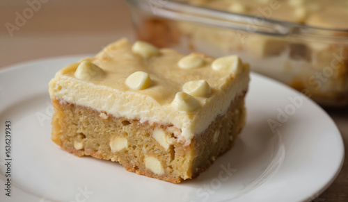Delicious white chocolate chip blondie squares on plate. Creamy dessert, sweet baked slice, homemade snack. Tasty brown brownie from bakery shop with sugar. Perfect for cafe menu.
