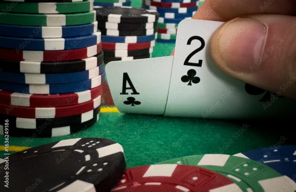 Obraz premium Close Up Shot On Hand Of Anonymous Poker Player Checking Playing Cards He Was Dealt. Professional High Stakes Gambler Making A Bet, Thinking Of Strategy, Counting Chips In Competitive Tournament.