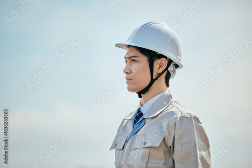 Foto 遠くを見つめる作業服姿の男性