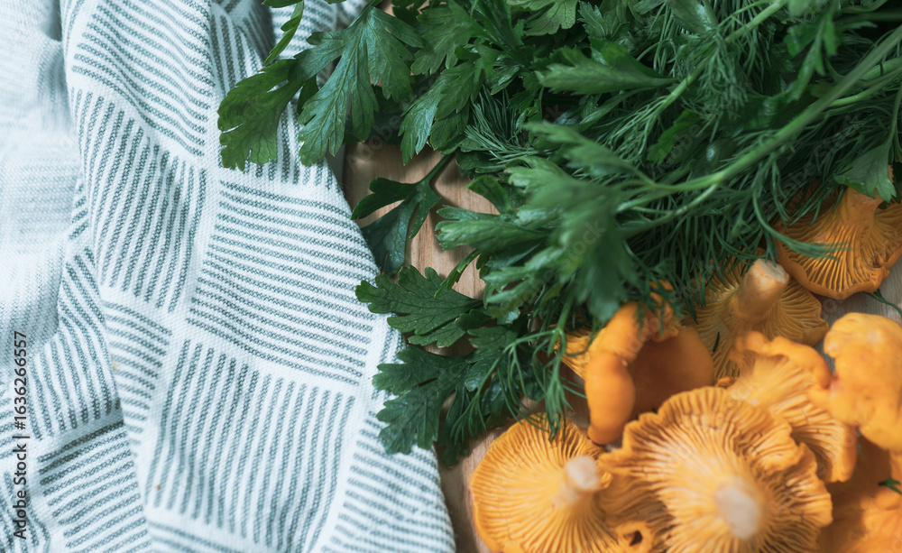 Fototapeta premium Fresh parsley with chanterelle mushrooms and kitchen towel background