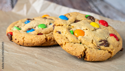 Two Homemade Chocolate Chip Cookies with M&Ms on Parchment Paper