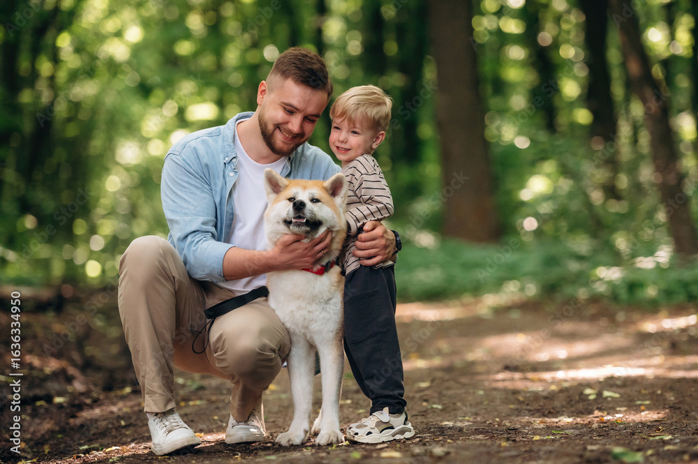 Fototapeta premium Cute pet, sitting and having fun. Father with son and dog are in the forest