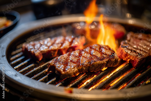 Close up shot grilled meat on charcoal fire in restaurant, Barbecue steak grilled on fire, Korean style grilled beef on charcoal with kimchi.