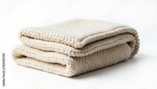 Folded knitted throw blanket in a light beige color.