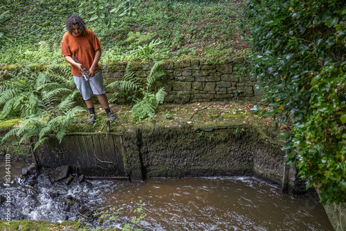 Person enjoys nature by a small stream in a park