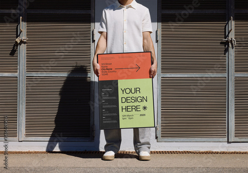Mockup Of Man Holding Customized Framed Poster By Building