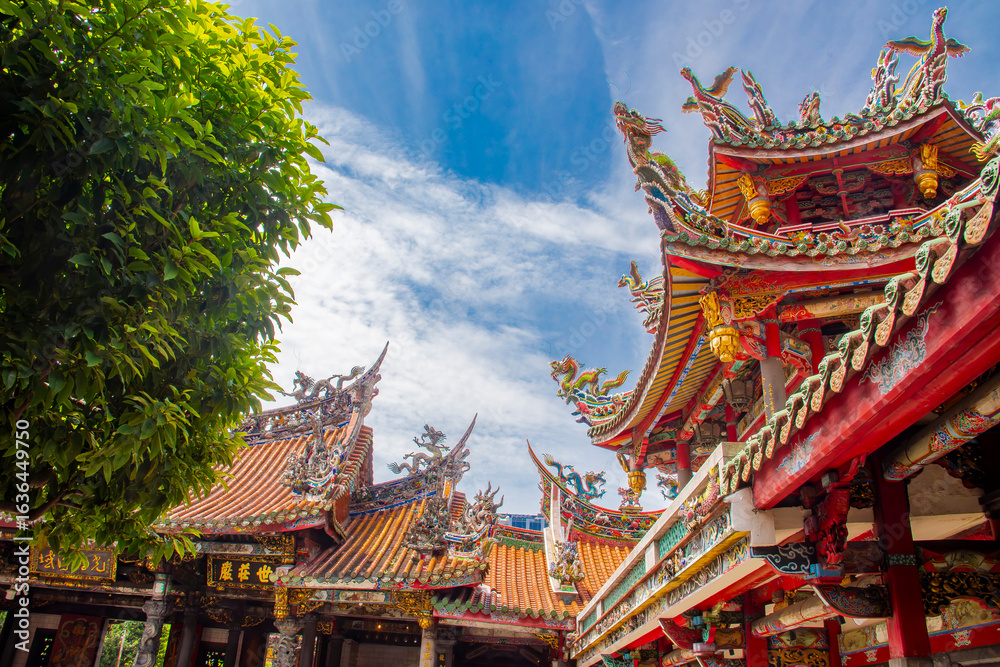 Fototapeta premium The view of Lungshan Temple in Taipei’s Wanhua District (also known as Monga) features traditional Chinese architecture with intricately carved wooden beams, colorful. 