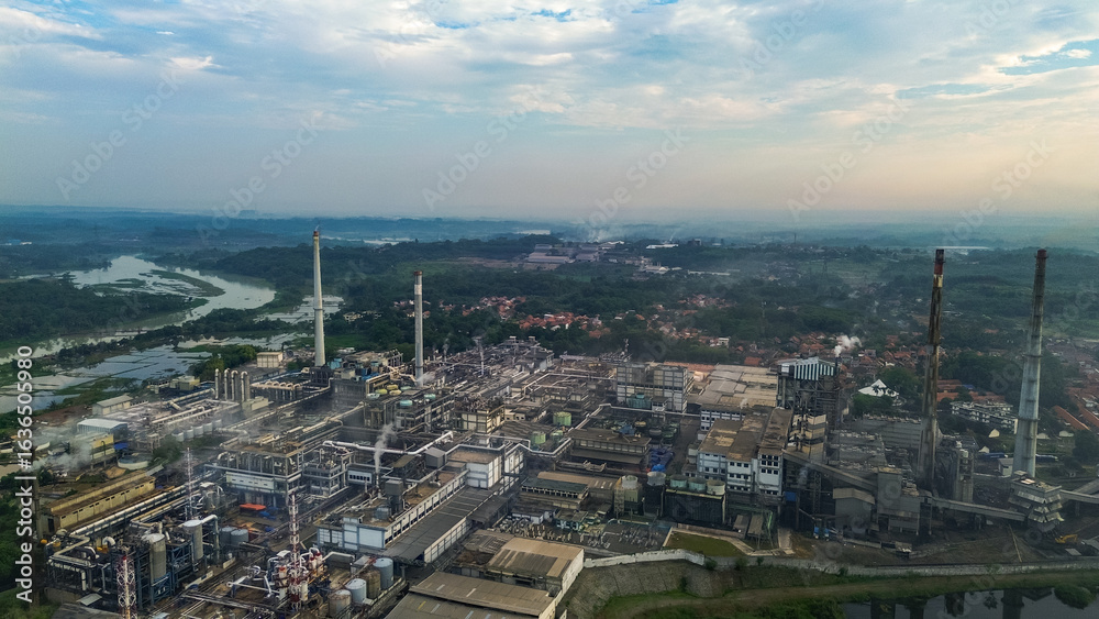 Obraz premium Aerial drone view of a large industrial factory complex with warehouses, chimneys, and storage tanks in Asia