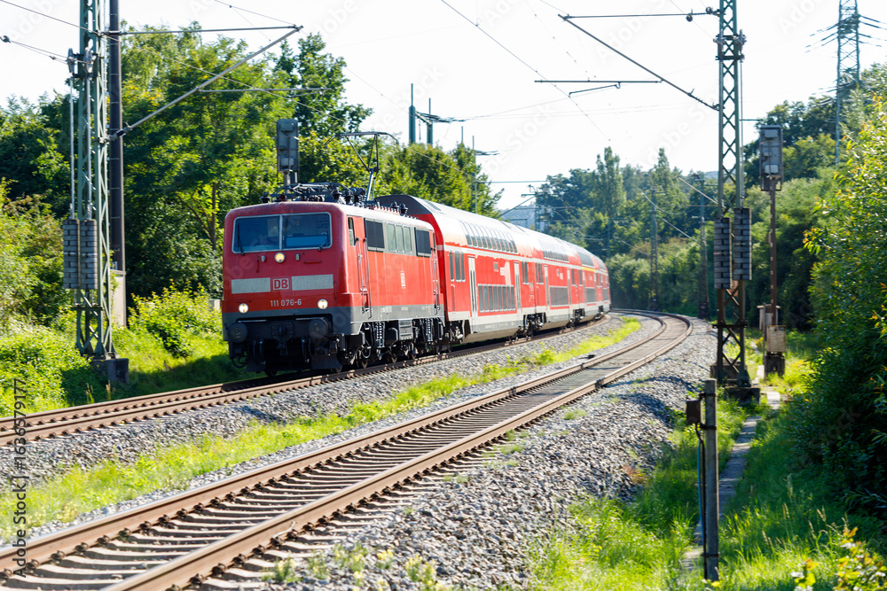 Naklejka premium German Red DB Train on Tracks Through Green Landscape