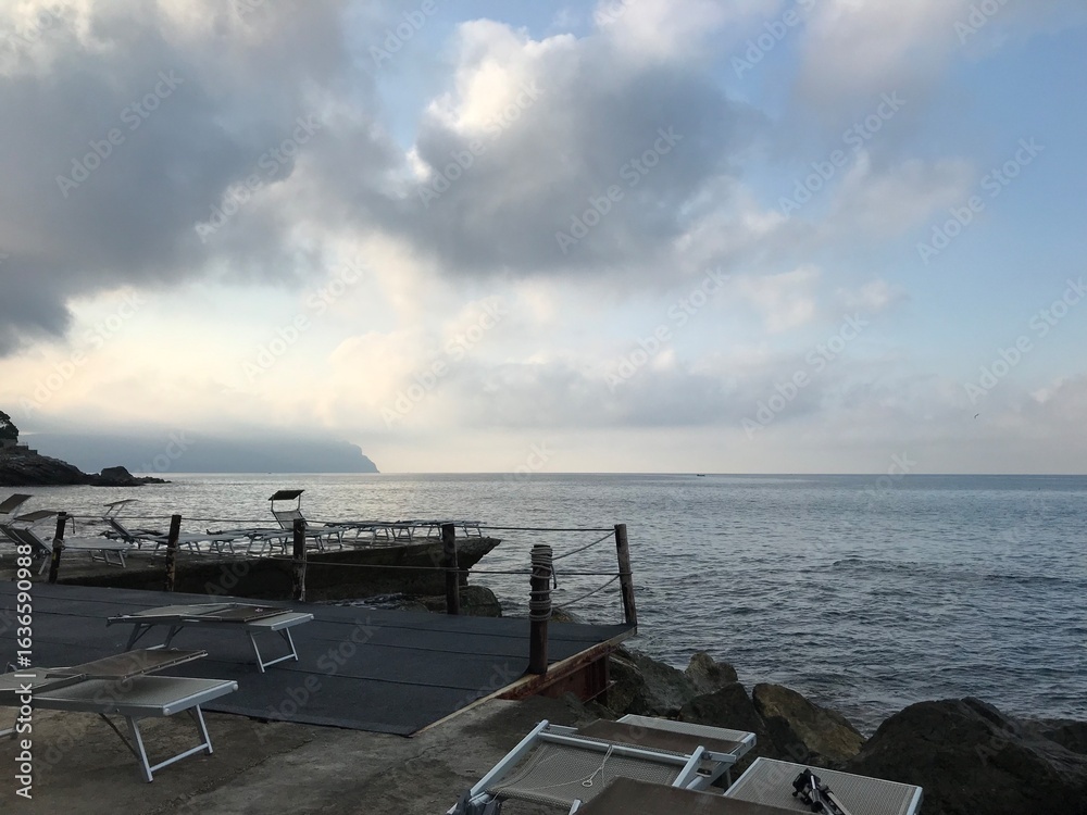 Obraz premium Italian coastal town with rocky waterfront at dawn. 