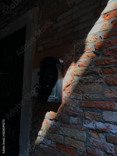Historic buildings with peeling paint near a Venetian canal.
