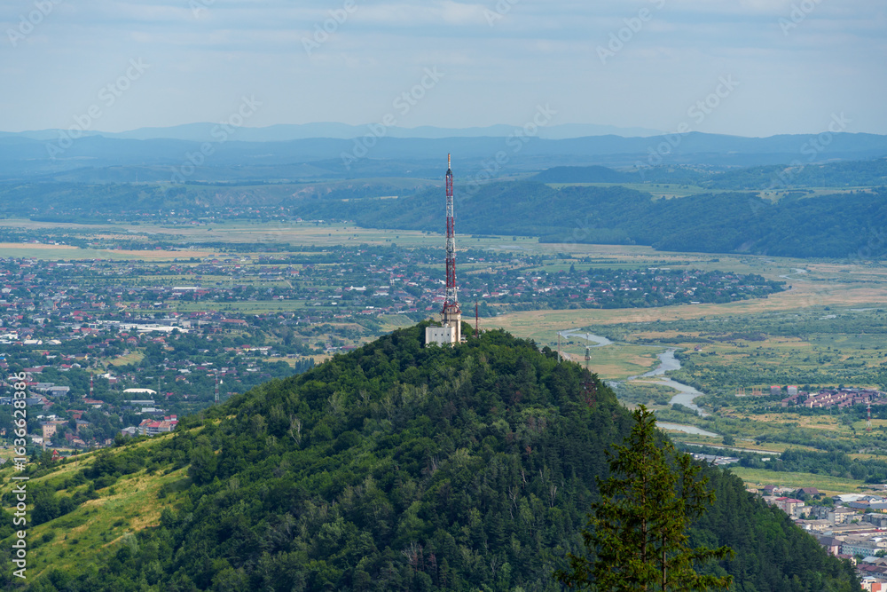 Fototapeta premium panoramic view from above of the streets of Piatra Neamt, Romania, and the hill with the communication tower, urban architecture, urban landscape