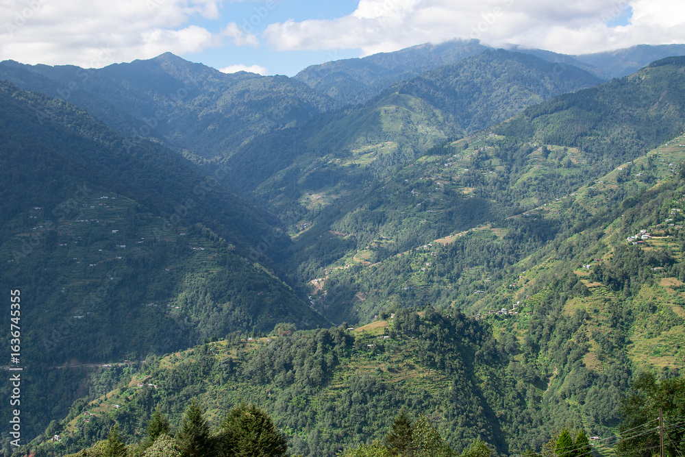Naklejka premium Sun rays falling on Himalayan mountain range, scenic beauty of layers of mountains, Okhrey, sikkim, India. Okhrey village a remote place in Sikkim where mountain range view is enjoyed by tourists.