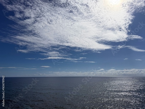 Sticker Beautiful sky clouds over glittering ocean.