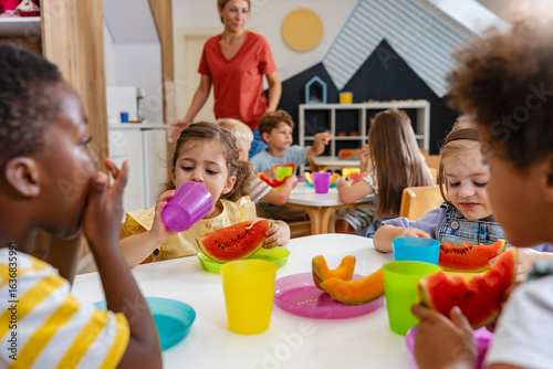 Konstfotografi Preschool children eating fresh watermelon slices at table, enjoying healthy sna