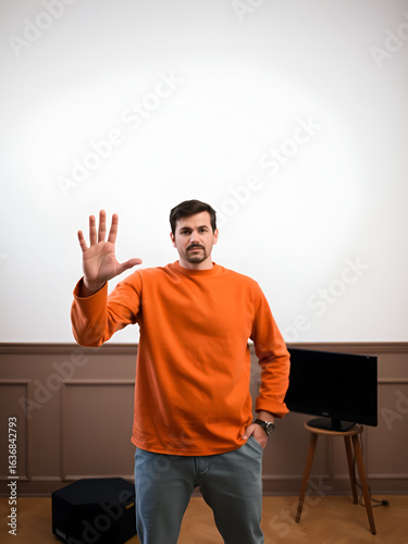 single person stands confidently in welllit room demonstrating gesture of admonishment