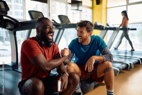 Slika na platnu Cheerful sportsmen supporting each other during gym workout.