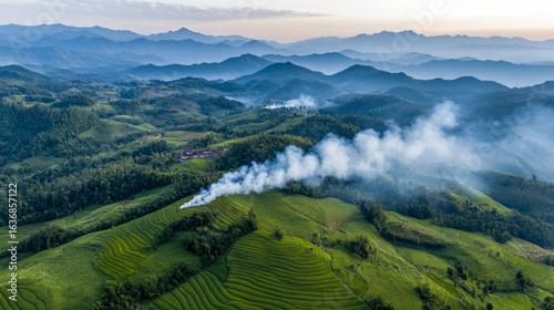 Sunrise over Verdant Terraced Hills with Rising Smoke and Distant Mountains, Showcasing Rural Agriculture and Haze