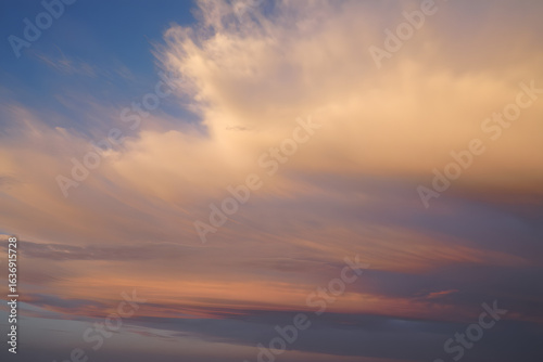 Ethereal twilight sky with a painterly canvas of soft, wispy clouds in warm sunset hues of orange and pink.