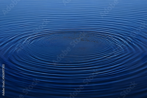 Abstract background of deep blue water with concentric circles and ripples from a central impact. Serene and tranquil liquid surface.