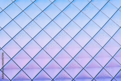 Futuristic abstract background featuring a diamond grid pattern with a vibrant blue to purple gradient. Modern geometric surface design.