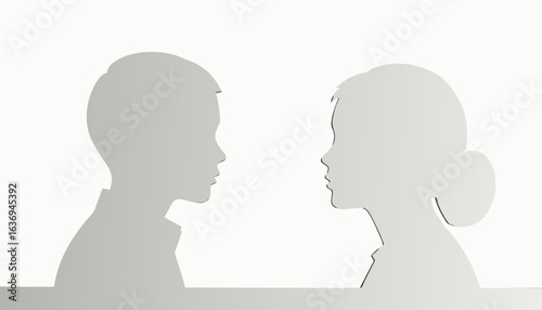Silhouettes of boy and girl facing each other in soft light  