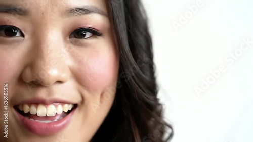 Closeup portrait of a joyful young Asian woman with beautiful makeup and a charming smile looking at the camera