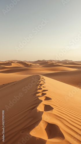 Serene Desert Landscape with Footprints on Sand Dune at Sunset