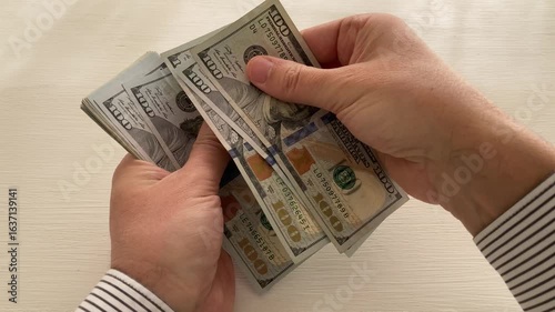 man counting money 100 US dollar bills, symbol for business or wealth