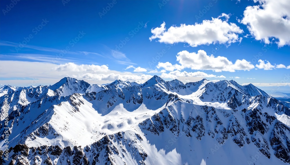 Obraz premium Snowy mountain peaks under a vibrant blue sky