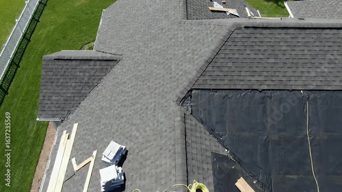 Aerial view of a residential roof under construction with new asphalt shingles being installed over the underlayment Home improvement and roofing repair project
