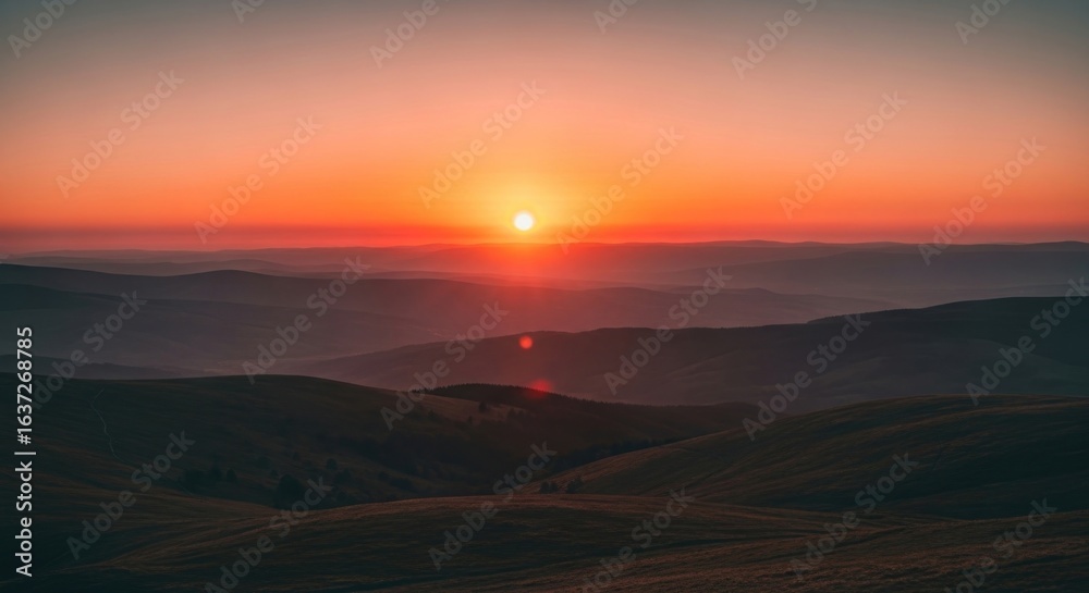 Obraz premium Sunset Over Rolling Hills with Vibrant Orange Sky, Creating a Peaceful and Serene Landscape, Ideal for Travel and Nature Photography