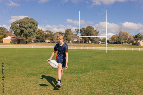 Fotografie Junior rugby union player chasing ball on field