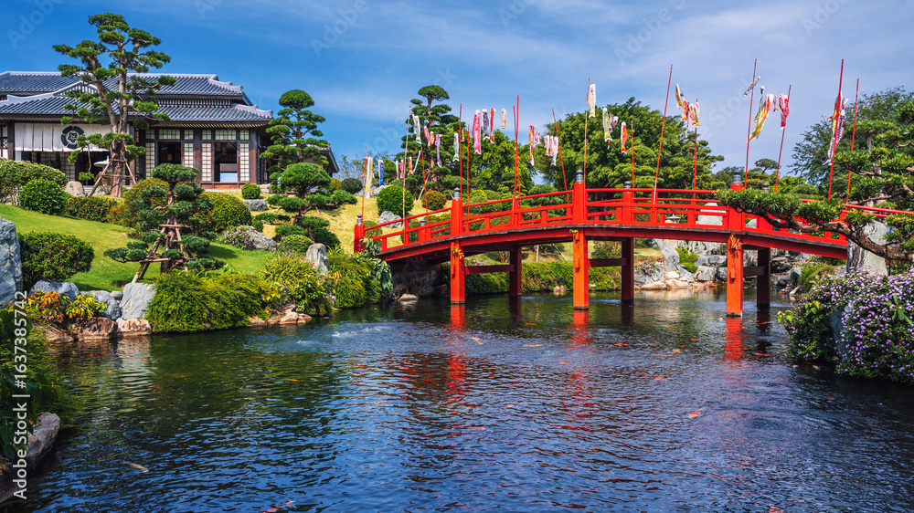 Obraz premium The exterior of a traditional Japanese tea house in a Japanese garden with a wooden bridge over a pond