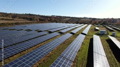 Aerial view of a vast solar panel farm generating clean energy on a sunny day.
