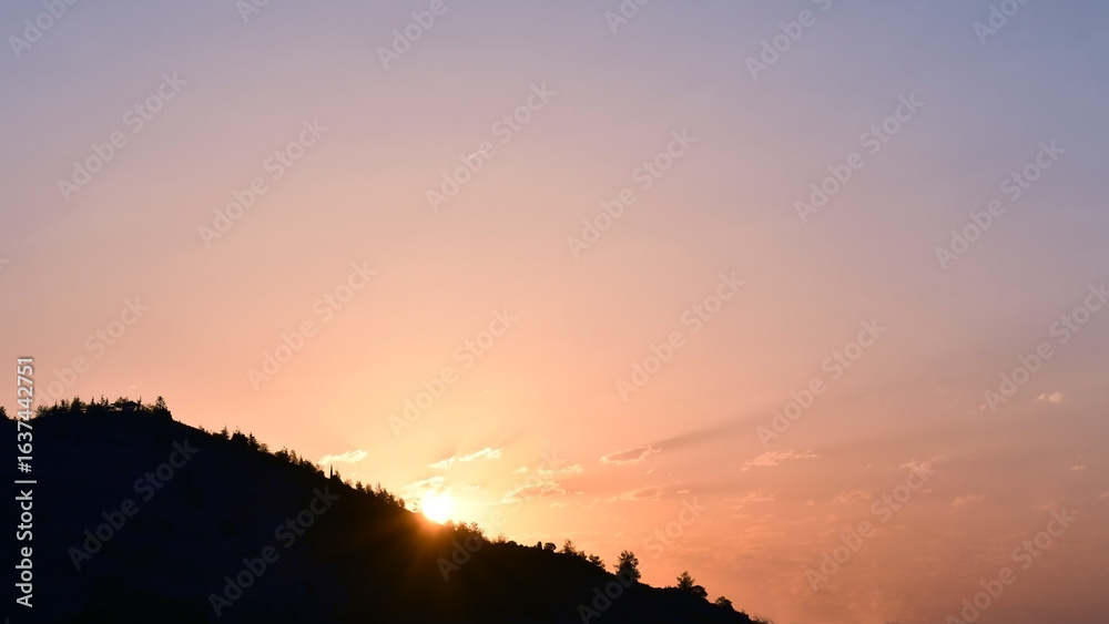Fototapeta premium Sunrise shining through the mountain. Golden yellow orange blue sky and cloud in the morning. Beautiful nature in countryside. Sunset sky.