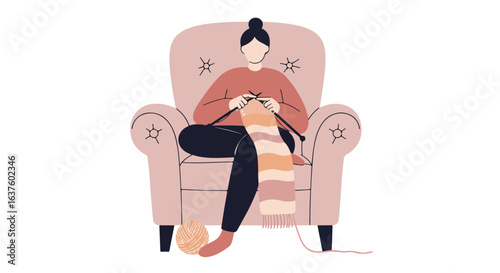 Woman sits knitting in an armchair with a wool yarn ball and half-finished scarf