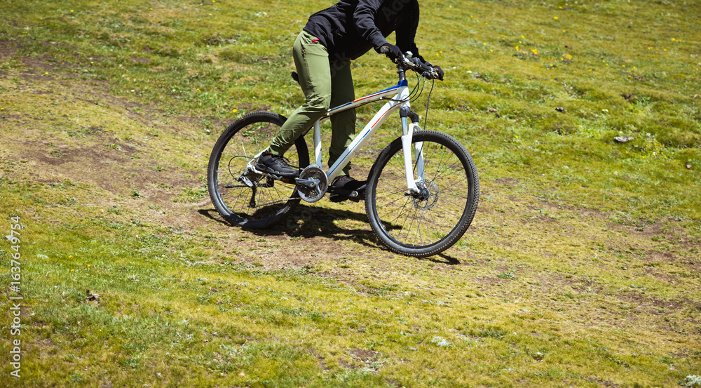 Obraz premium Riding mountain bike on grassland mountains