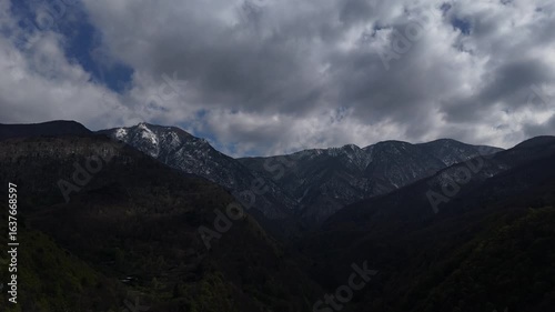 An Atmospheric Drone Vista Over Bursa Reveals Dark, Verdant Mountains Embracing the Sublime Snow-Capped Majesty of Uludağ