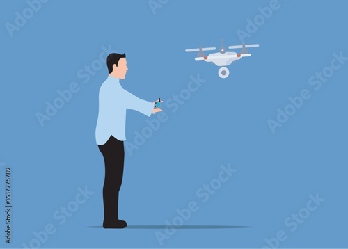 A man in a light blue shirt and black pants operates a drone with a remote control against a solid blue background.