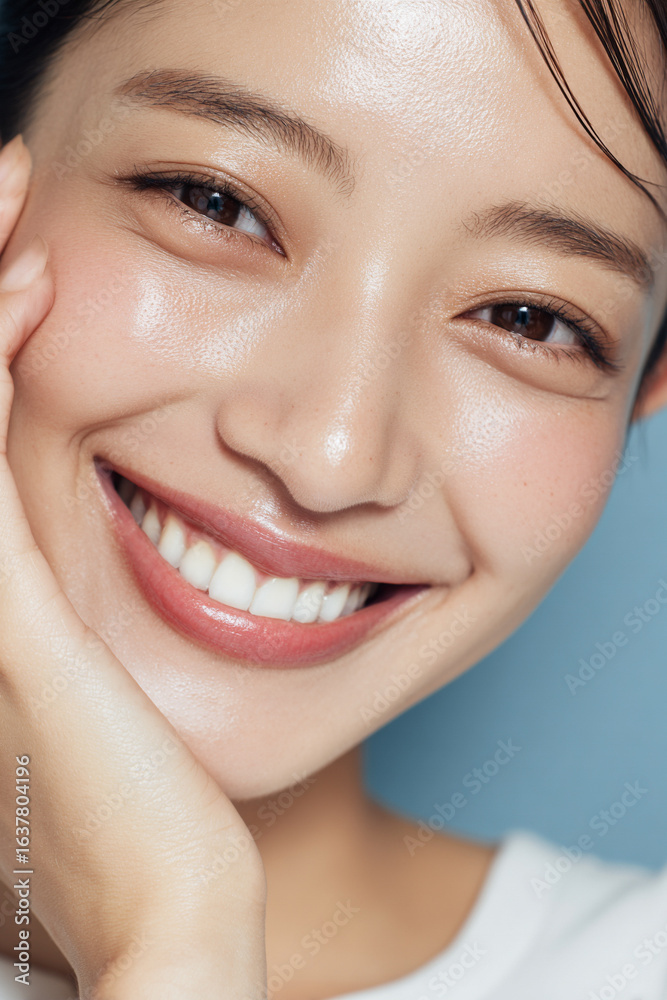 Obraz premium 笑顔できらめく綺麗な肌と白い歯を見せる日本人女性美人モデルの接写写真。オーラルケア、スキンケア、コスメ広告用。