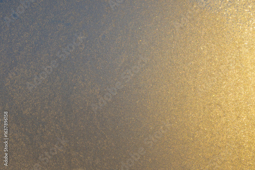 Texture of glass covered with frost with gradient from sunlight