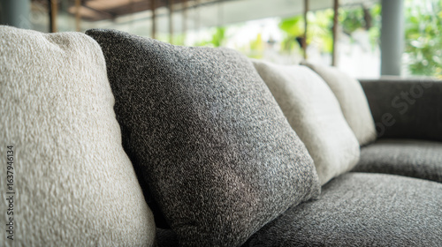 A contemporary sofa with textured neutral-toned cushions in an elegant living space.