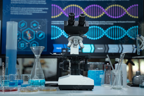 Asian scientist wearing lab coat and gloves using a microscope in a high tech laboratory focused on DNA research biotechnology healthcare and scientific innovation