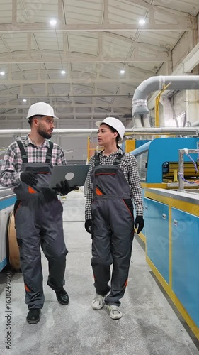 Engineers discussing production process in modern factory
